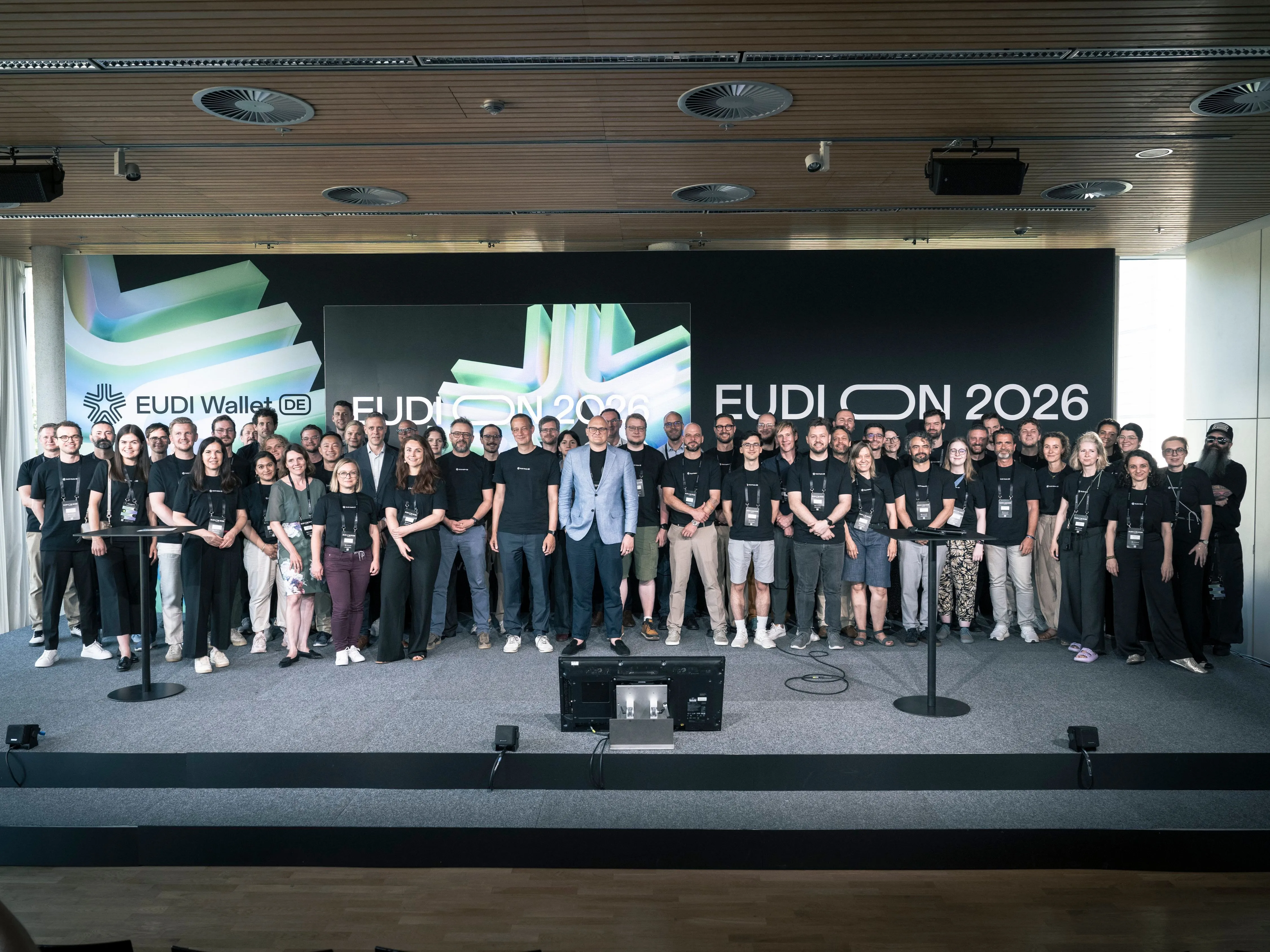 Group photo of the national EUDI Wallet project on stage at EUDION 2026 in front of a large EUDI Wallet projection