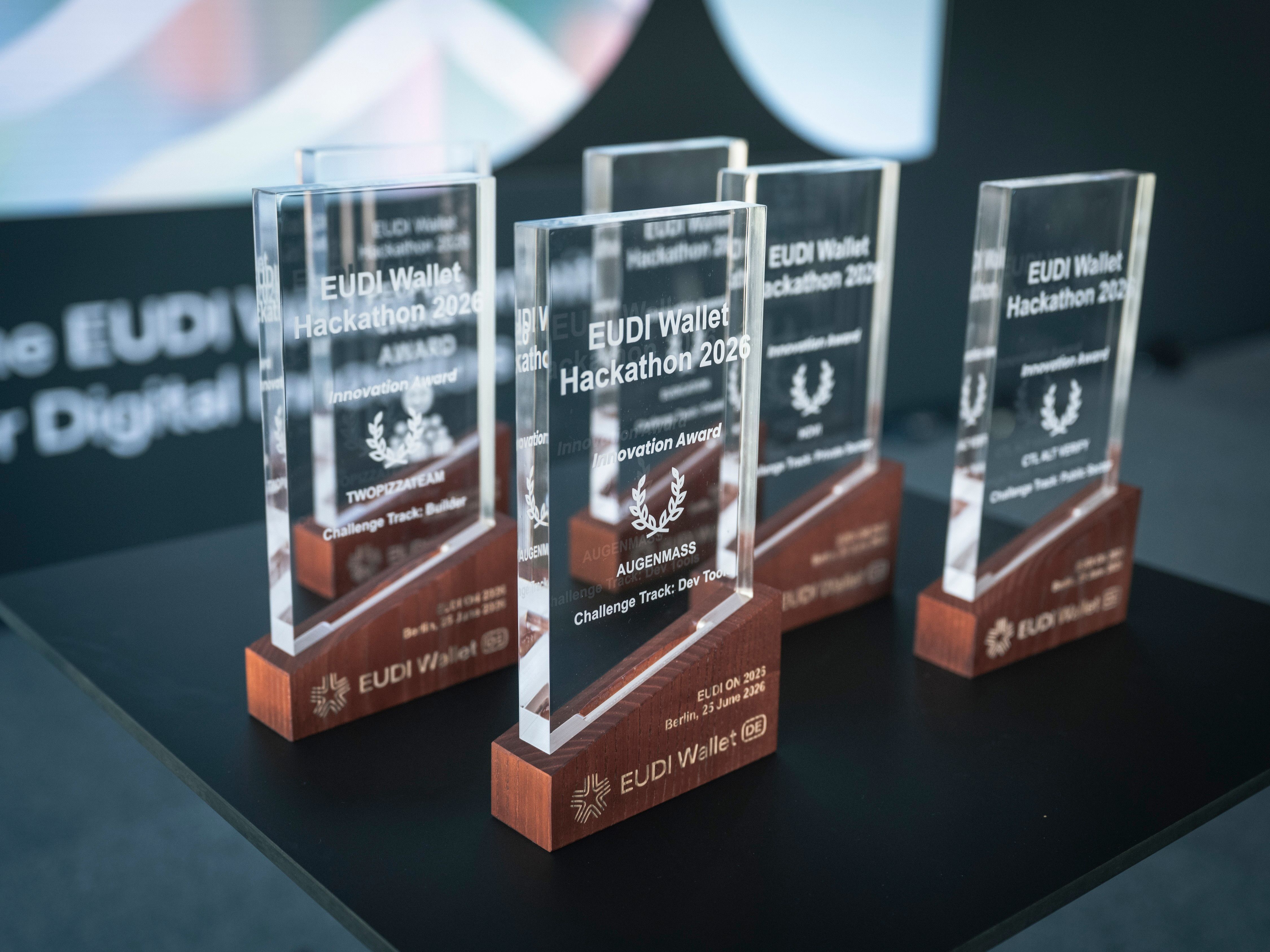 Mehrere Glas‑Trophäen für den EUDI Wallet Hackathon 2026 stehen auf einem Tisch, ausgezeichnet als Innovation Awards