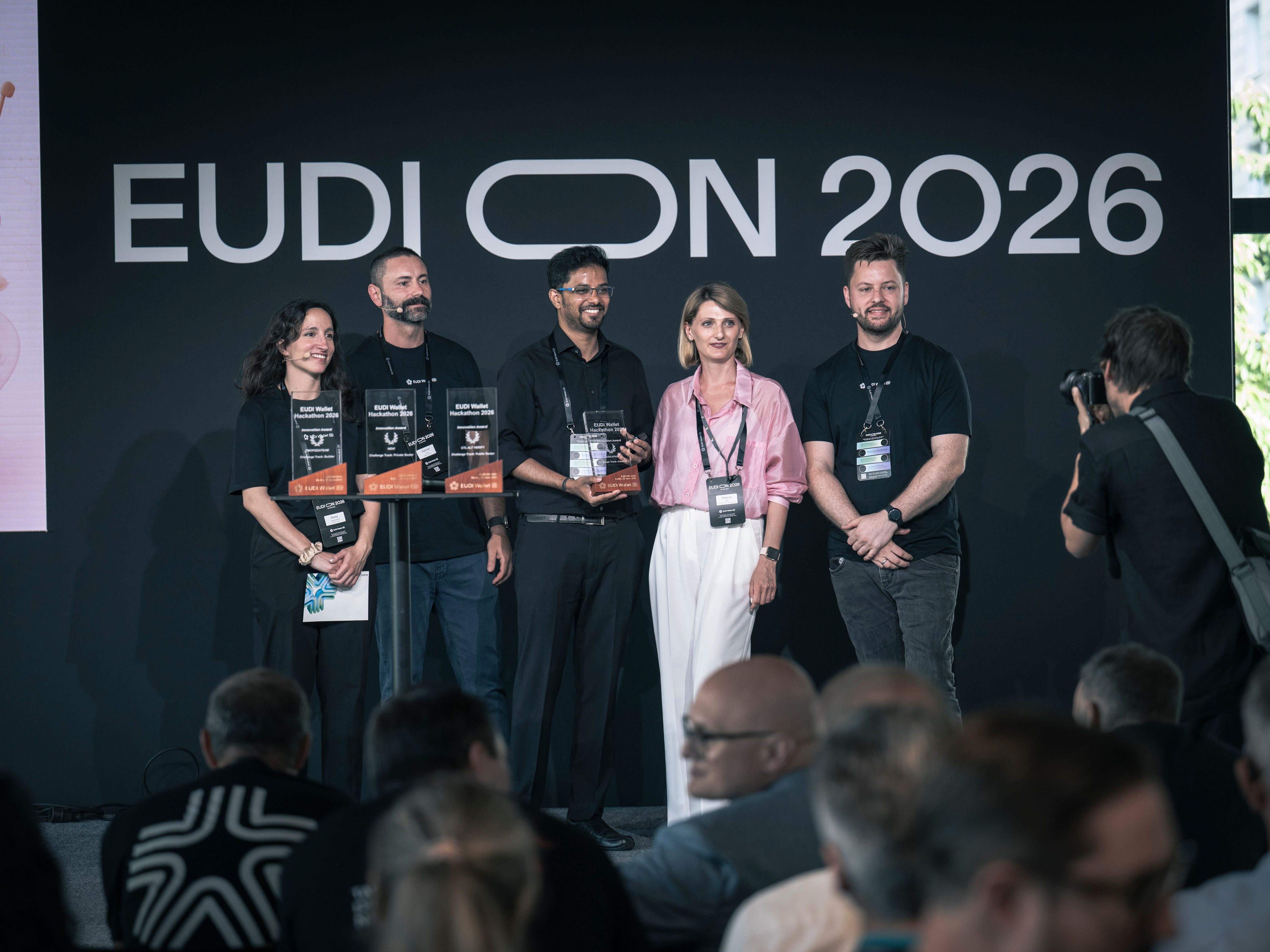 Eine Gruppe von fünf Preisträgern mit Urkunden und einer Trophäe steht auf der Bühne der EUDI ON.